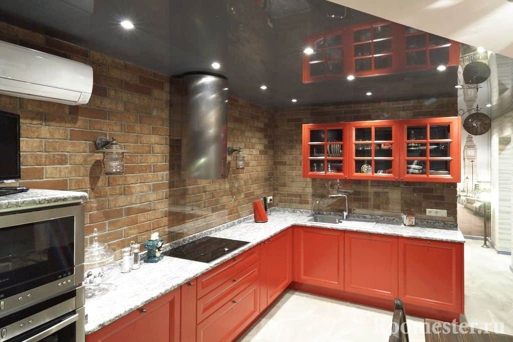 Угловая кухня в красном цвете без верхних шкафов над рабочей поверхностью