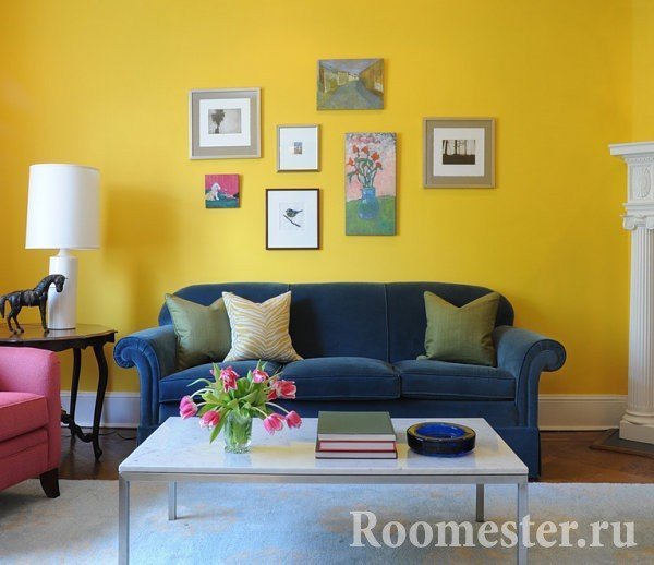 Синий диван на фоне желтой стены