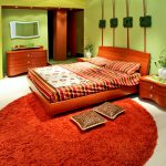 Салатовые стены и оранжевый ковер в спальне