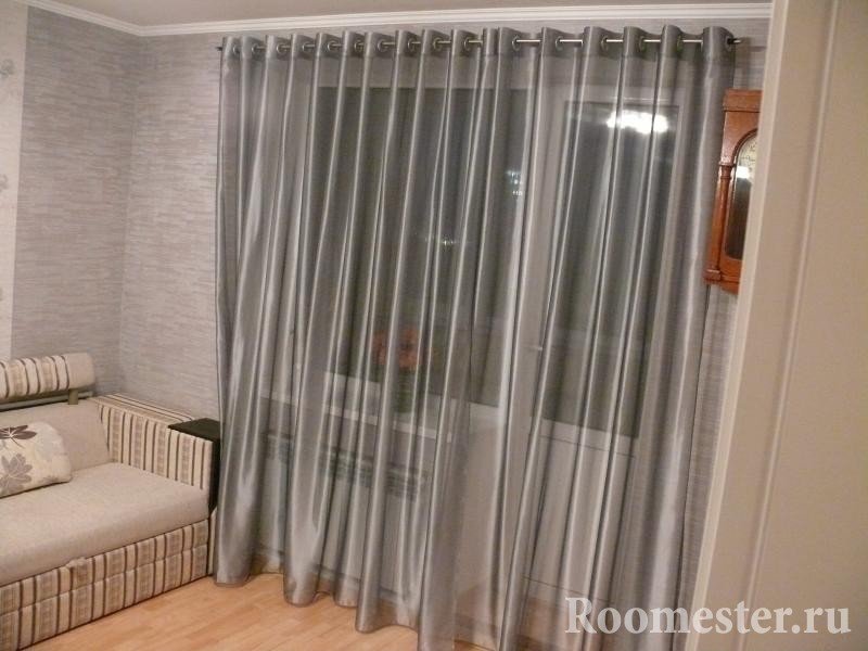 Серые шторы и бежевый диван в комнате