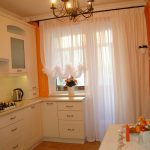 Оранжевые стены и белая мебель на кухне
