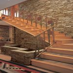 Стены с декоративной плиткой под камень и деревянная лестница