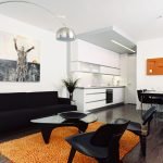 Черная мебель и оранжевый ковер в гостиной