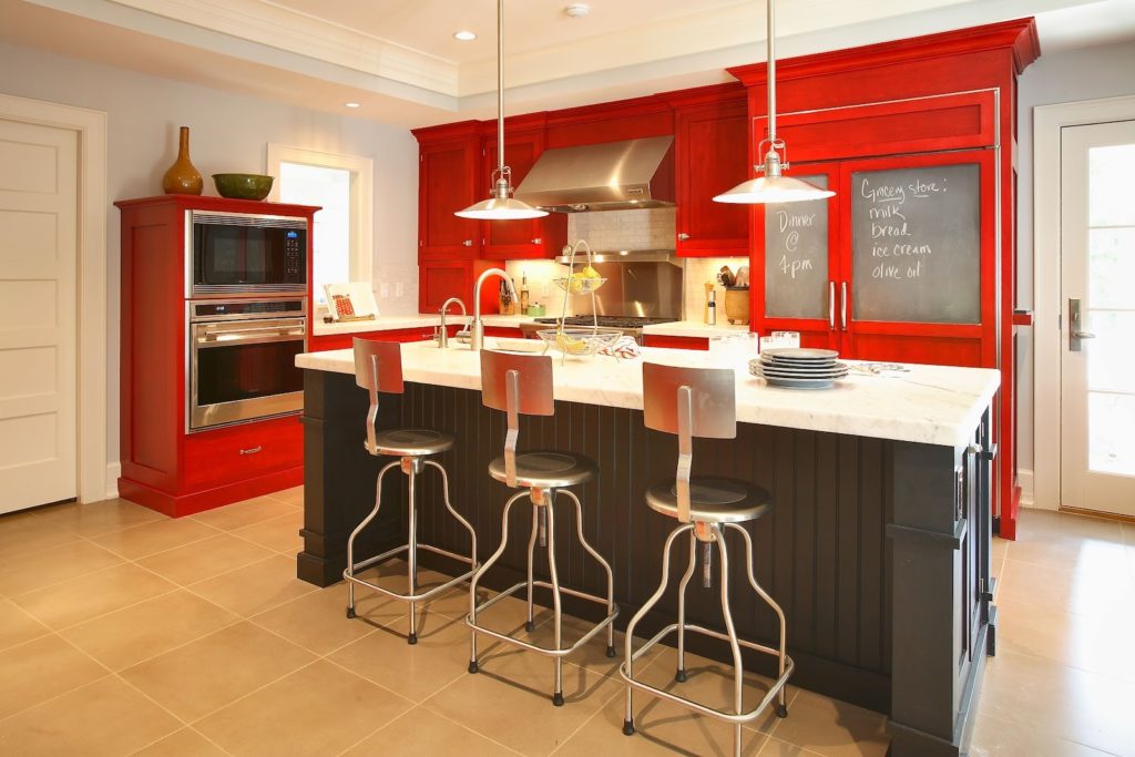Многоуровневый потолок на кухне с красной мебелью