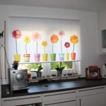Горшки с цветами на шторе на кухне