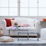 Красные и розовые подушки на белом диване