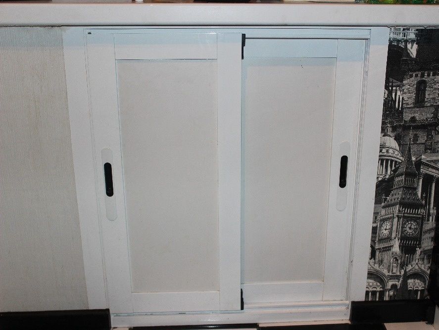 Холодильник с дверками из ЛДСП под окном